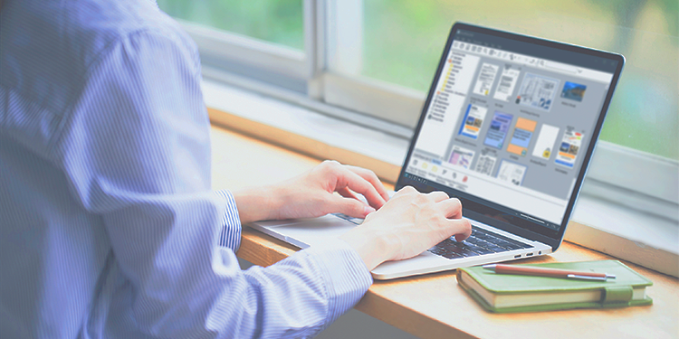 一人在窗边使用笔记本电脑。